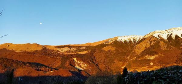 Scenic view of mountains against clear blue sky