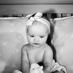 Cute baby boy sitting on sofa