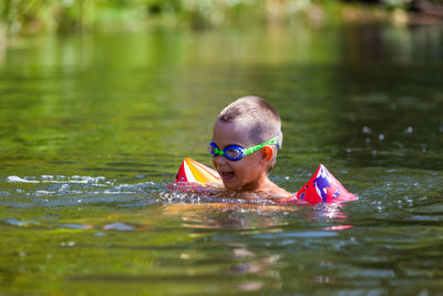 Portrait of shirtless boy swimming in lake