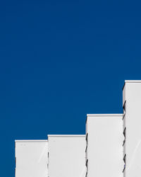 Low angle view of white building against clear blue sky