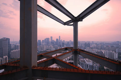 Bridge and buildings against sky during sunset