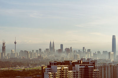 Buildings in city against cloudy sky