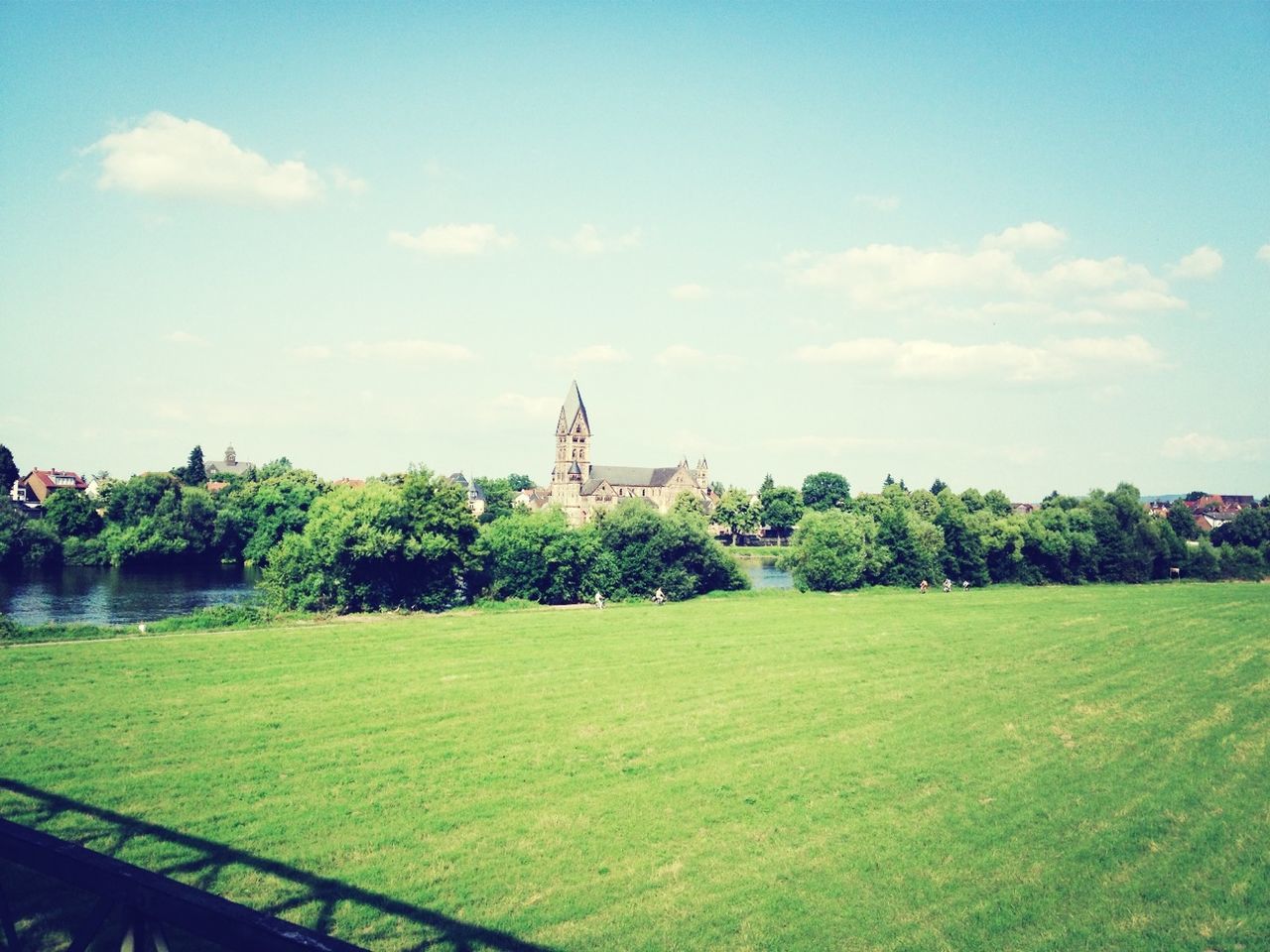 grass, sky, green color, built structure, tree, architecture, cloud - sky, building exterior, field, growth, plant, cloud, grassy, nature, day, park - man made space, landscape, lawn, green, outdoors