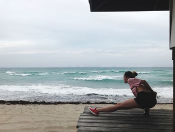 Woman stretching leg at beach