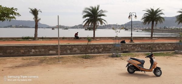People riding bicycle on road against sky