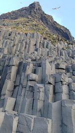 Stone wall by mountain against sky