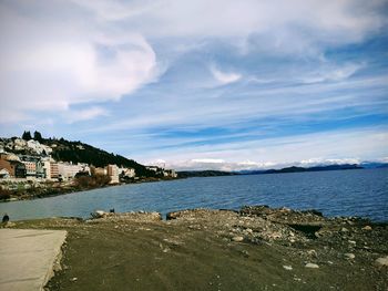 Scenic view of sea by buildings against sky