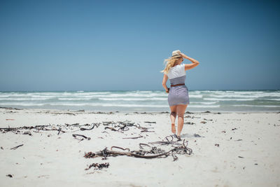 Rear view of woman walking at beach