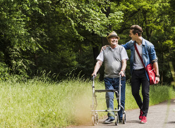 Happy grandfather walking with his grandson in nature