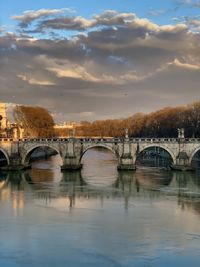 Bridge over river against sky during sunset