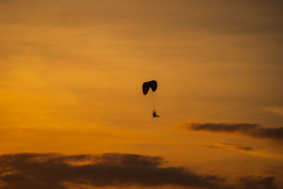 Low angle view of silhouette balloons against sky during sunset