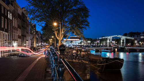 Light trails on city street against sky at night