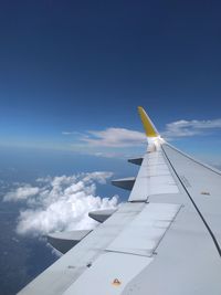 Airplane flying over clouds against blue sky