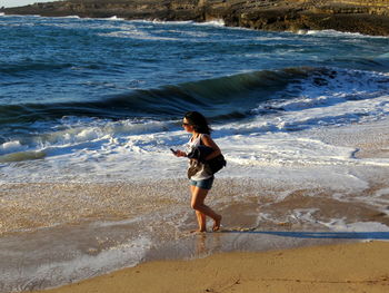 High angle view of girl walking at beach on sunny day