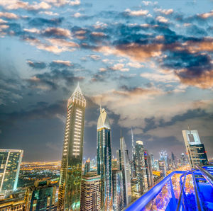 Illuminated modern buildings against sky in city