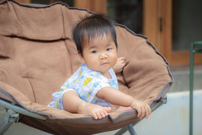 Portrait of cute baby girl sitting on floor