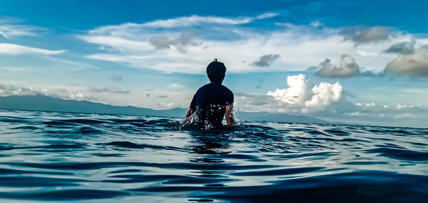 Rear view of man swimming in sea