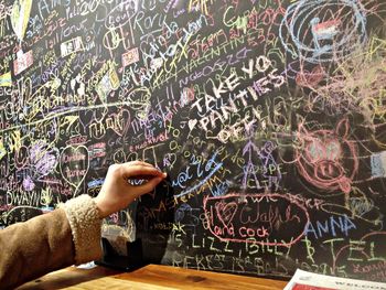 Cropped hand writing on blackboard