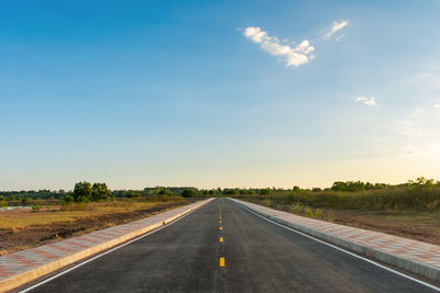 Road passing through land against sky