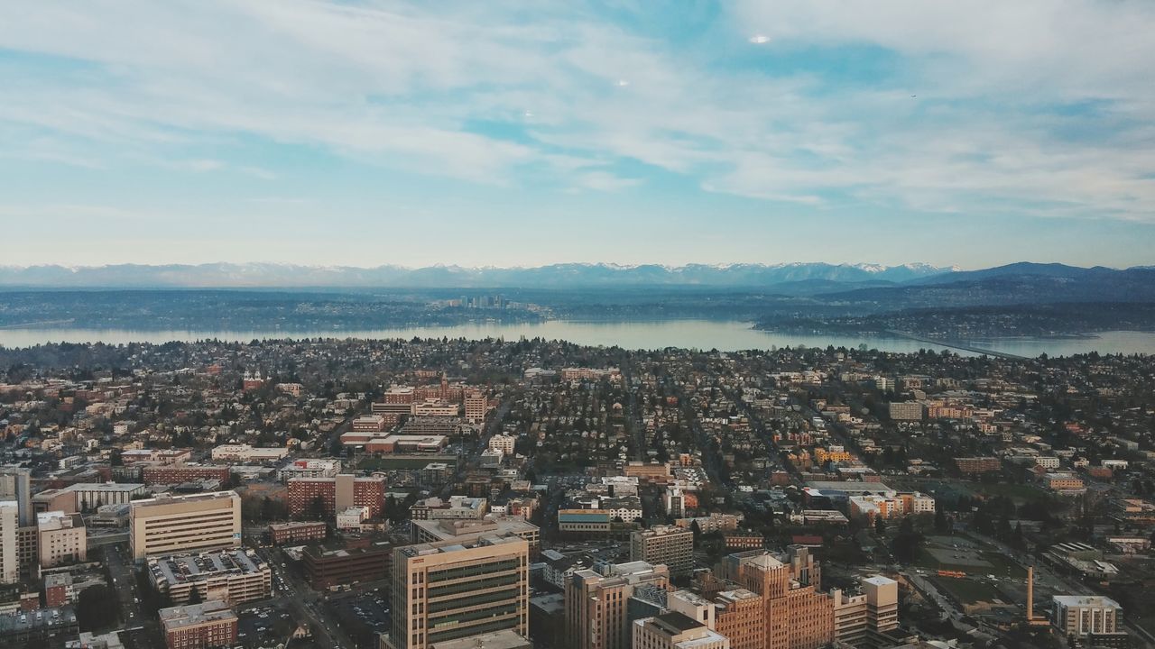 cityscape, architecture, building exterior, city, built structure, crowded, sky, high angle view, water, residential district, sea, cloud - sky, residential building, residential structure, cloud, aerial view, city life, skyscraper, river, outdoors