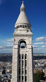 Bell tower in city against sky