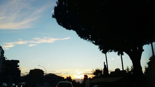 Silhouette of city against sky at sunset