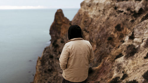 Rear view of man standing on rock