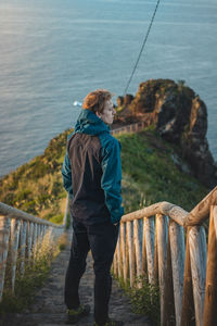 Student wearing a jacket enjoys the view from cristo rei, camara de lomos, madeira, portugal