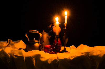 Close-up of lit candles against black background