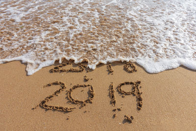 2018 and 2019 on the sandy beach ocean wave. new year concept