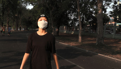 Portrait f young woman wearing mask on road