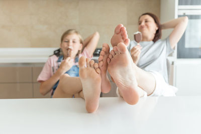 Side view of woman sitting on bed at home