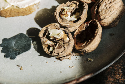 Close up of open walnuts near a nutpick in a plate for breakfast