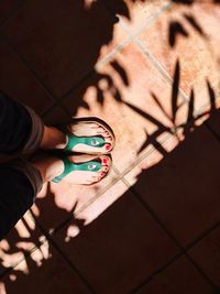 Low section of woman standing on tiled floor