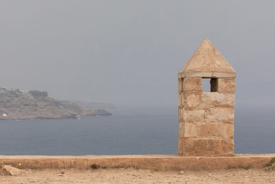 Building by sea against clear sky