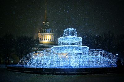 Water fountain in illuminated city at night