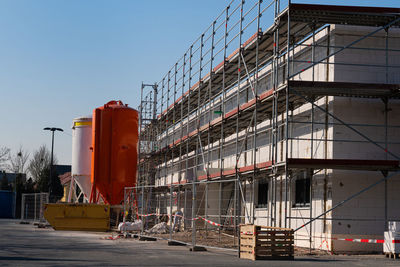 Building under construction in scaffolding. two cylindrical elevators for loose building materials.