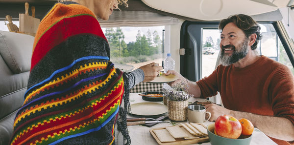 Happy couple eating food in motor home