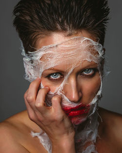 Close-up portrait of beautiful woman against black background