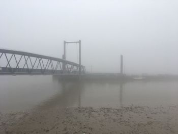 Scenic view of bridge against sky during foggy weather