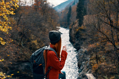 Rear view of man standing on mountain during autumn