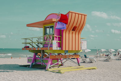 Lifeguard hut on beach against sky