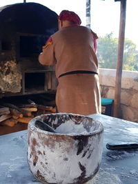 Rear view of man working on table by building