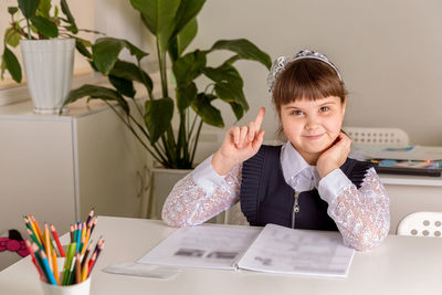 A girl pupul sits at a desk in the classroom and reads a book. back to school concept