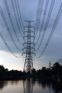 Low angle view of silhouette electricity pylon against sky at dusk