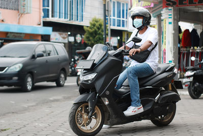 Man riding a 150 cc nmax motorcycle during a pandemic