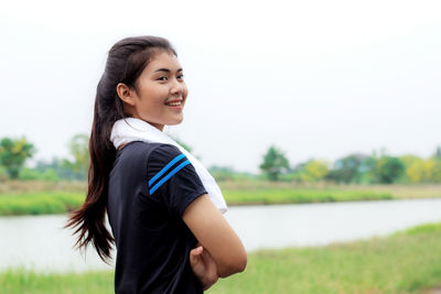 Young woman standing against sky