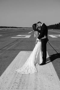 Married couple kissing on runway