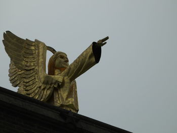 Low angle view of angel statue against clear sky