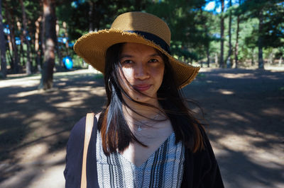 Portrait of young woman wearing hat standing outdoors